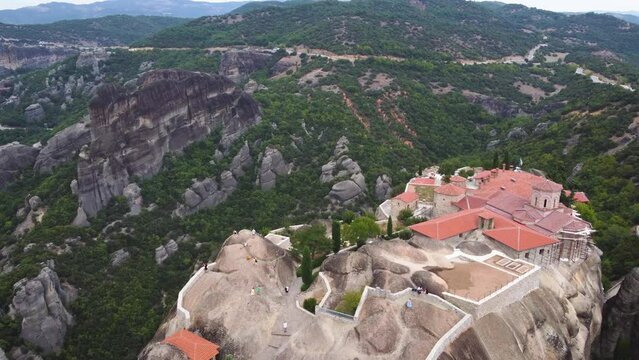 Aerial top view of Monastery of the Holy Trinity (Agia Triada) in Meteora, Greece with Kalabaka town and mountains in the background