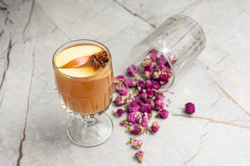 Glass of hot mulled wine with cinnamon, anise and dried flowers
