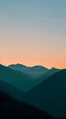 Obraz premium The horizon shows a stunning contrast of orange and blue hues with mountain peaks at twilight