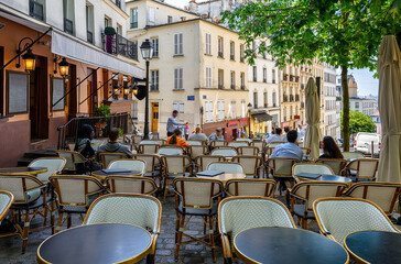 Cozy street with tables of cafe in quarter Montmartre in Paris, France. Architecture and landmarks of Paris. Postcard of Paris - 772528199