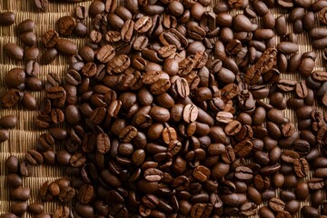 Obraz premium Heap of roasted coffee beans arranged intricately on a matting