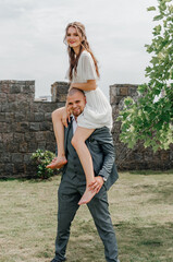 the groom holds the bride on his shoulders