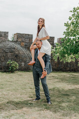 the groom holds the bride on his shoulders