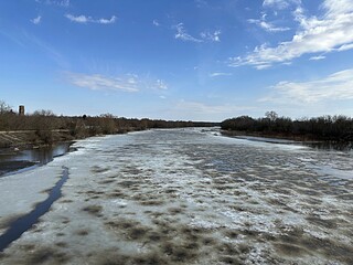 flood on the river in spring. ice floes float on the river against the background of a blue sky...