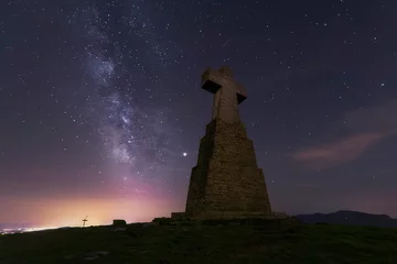 Tuinposter night view on a summer night with the starry sky and the milky way over the cross of Mount Saibigain in the Urkiola Natural Park, Bizkaia © patxi
