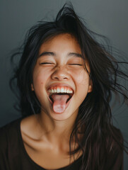happy asian woman sticking tongue out - obrazy, fototapety, plakaty
