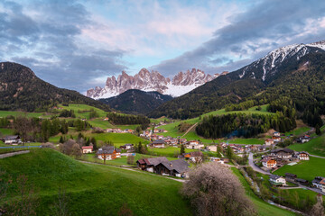 Fototapeta na wymiar Sunset landscape with Santa Magdalena village against the Geisler mountains covered with snow, Val Di Funes valley in Dolomites mountains, South Tyrol, Italy. Italian Alps in springtime