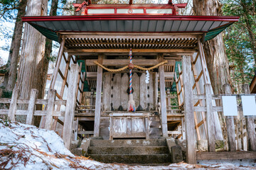 Snow-Dusted Shrine with Vibrant Accents in a Nagano Forest, A Sacred Space in Winter