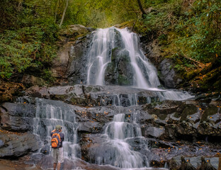 View of waterfall in Smoky Mountains, Tennessee with a figure of photographer taking photo of it