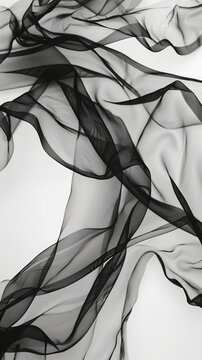 Fluttering chiffon and organza fabric in black and white. Translucent textiles with delicate movement.