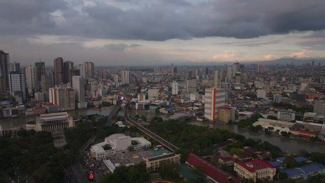 Aerial panoramic view of metropolis at twilight. Various town development in city. Pasig river flowing through town. Manila, Philippines