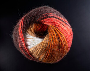 A ball of yarn with a red stripe and a white stripe