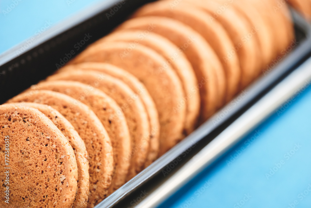 Poster A tray of cookies is sitting on a counter. The cookies are all the same size and are arranged in a row