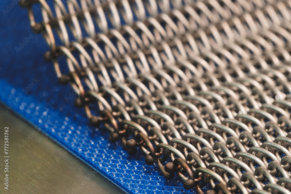 Poster A close up of a metal chain with many small links. The chain is silver and has a metallic look