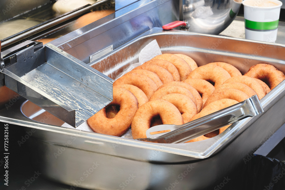 Poster A stack of donuts with a brown glaze. The donuts are piled on top of each other, creating a visually appealing and appetizing display