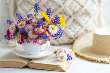 Flower arrangement with daisy and other summer flowers in a white cup. Spring floral composition. Greeting postcard for Mother's or Women's day, birthday, anniversary. Cozy atmosphere