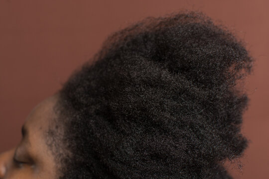 A woman with stretched out curly hair to emphasize shrinkage, 4c hair stretched to show shrinkage