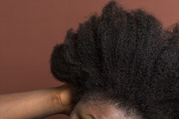 Black afro curly hair with shrinkage, Type 4c hair that is dry with a brown background - obrazy, fototapety, plakaty