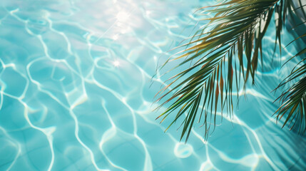Fototapeta na wymiar A palm tree branches above the clear blue calm water of the pool sparkling in the sun’s rays. Vacation happiness and tranquility concept background.