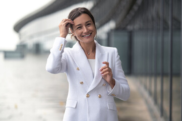 Woman in white jacket looking confident and contented