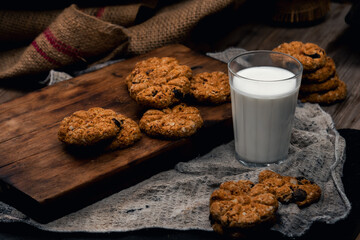 oatmeal and raisin cookies on wooden table with milk