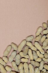 Unshelled peanuts scattered cardstock background copy space flat lay closeup food legume crop nutrition and allergy farming industry concept.