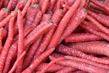 Random pile of crisp plump deep red Indian carrots seen at a vegetable stall near Kumbhalgarh village, Rajasthan, India