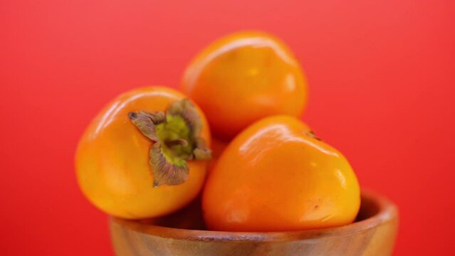 beautiful ripe persimmon in wooden plate