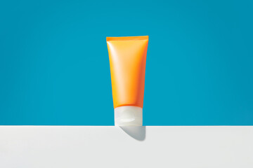 Sunscreen lotion on blue background with copy space. Body care beauty treatment concept
