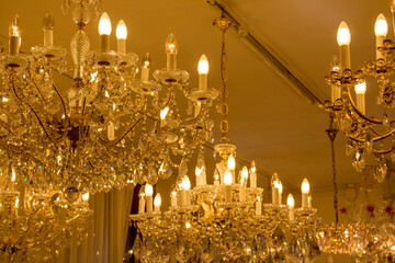 A majestic golden chandelier adorned with crystals provides a regal atmosphere, its candles illuminating the opulent interior