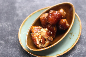 Details Dates stuffed with almonds on brown plate.  
