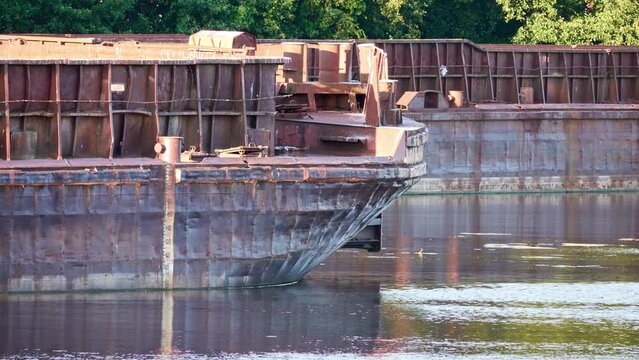 Old rusty barges on river in summer.