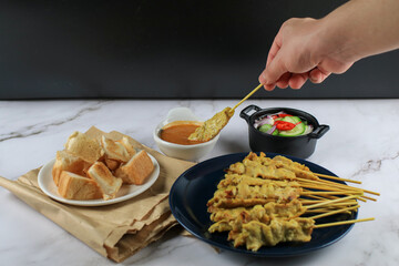 Pork Satay, Moo Satay Grilled pork served with peanut sauce or sweet and sour sauce on white table....