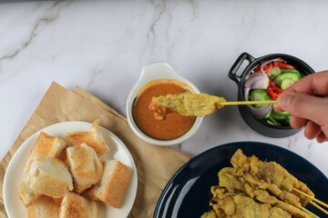 Pork Satay, Moo Satay Grilled pork served with peanut sauce or sweet and sour sauce on white table. Thai Asian food