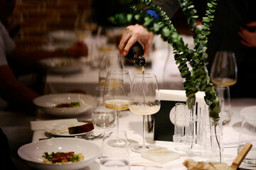 The waiter pours expensive champagne