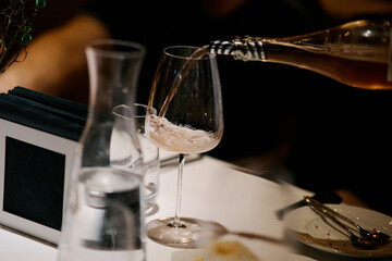 The waiter pours expensive champagne