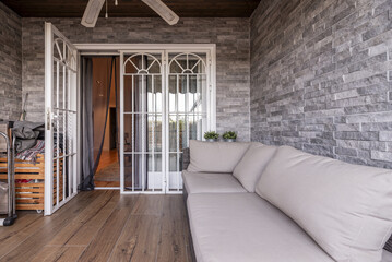 a terrace with imitation wood stoneware floors and decorative wooden furniture, a gray fabric sofa...
