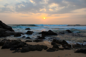 The sun setting into the sea at Delawella beach, Sri Lanka. Golden light