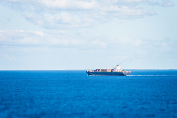 Cargo container ship sailing through calm Atlantic Ocean.