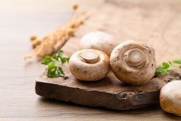 Fresh Champignon mushroom or button mushroom on wooden background