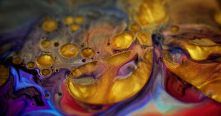 Glitter oil bubbles. Acrylic paint blend. Defocused golden yellow purple red color shiny metallic particles ink fluid pigment liquid with gloss gel drops abstract art background.