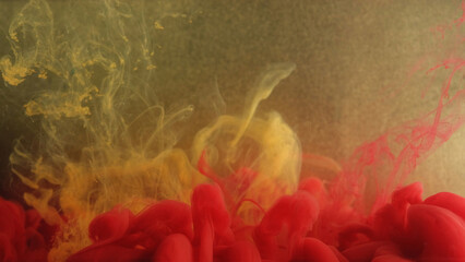 Smoke mix. Ink water flow. Yellow red vapor cloud splash fluid acryl texture on defocused gold color particles abstract art background.