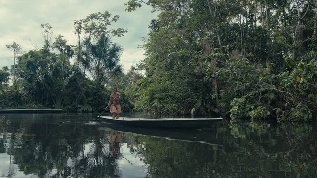 Huaorani boy in a canoe hunting