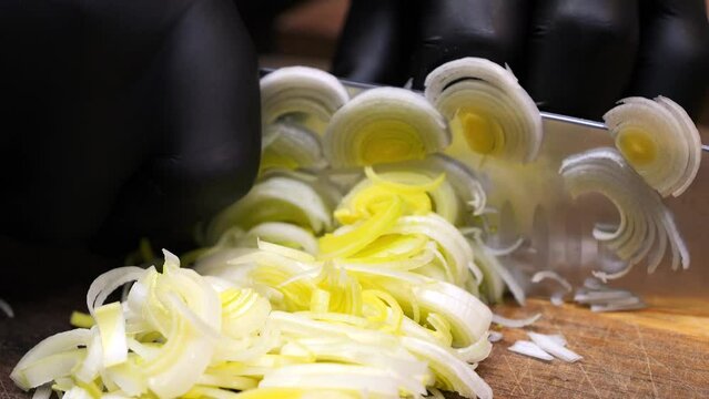 The chef slices leeks into thin slices