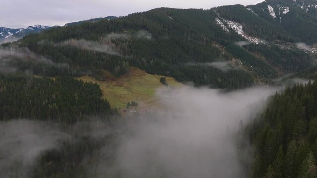 Misty mountains with green slopes in Saalbach-Hinterglemm, Austria, aerial view