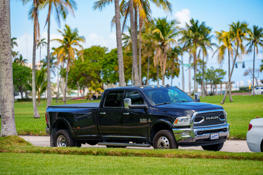 Black Ram 3500 pick up truck parked by a grass field