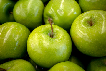 A pile of fresh ripe green apples in the supermarket