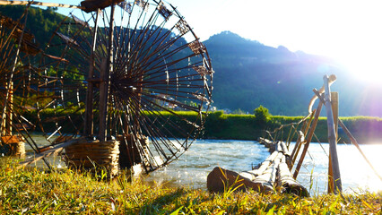 Wood water wheel Baler Machine in Agriculture Farm impeller lifted pumping water in river. Wooden Water Baler Machine green garden Farm blades by windy natural. Sustainable Resources Environment © aFotostock