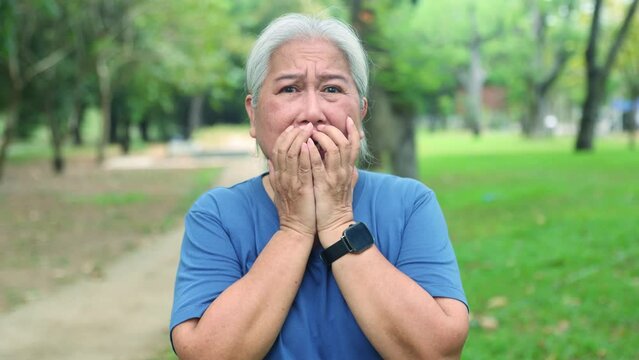 Panic shock horrified and crying elderly woman who witnessed the violent event caused negative fear showing frightened expression on her face using her hands cover her mouth frightening.