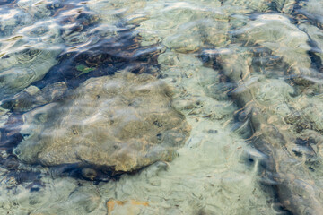 background of transparent sea water and bottom rocks